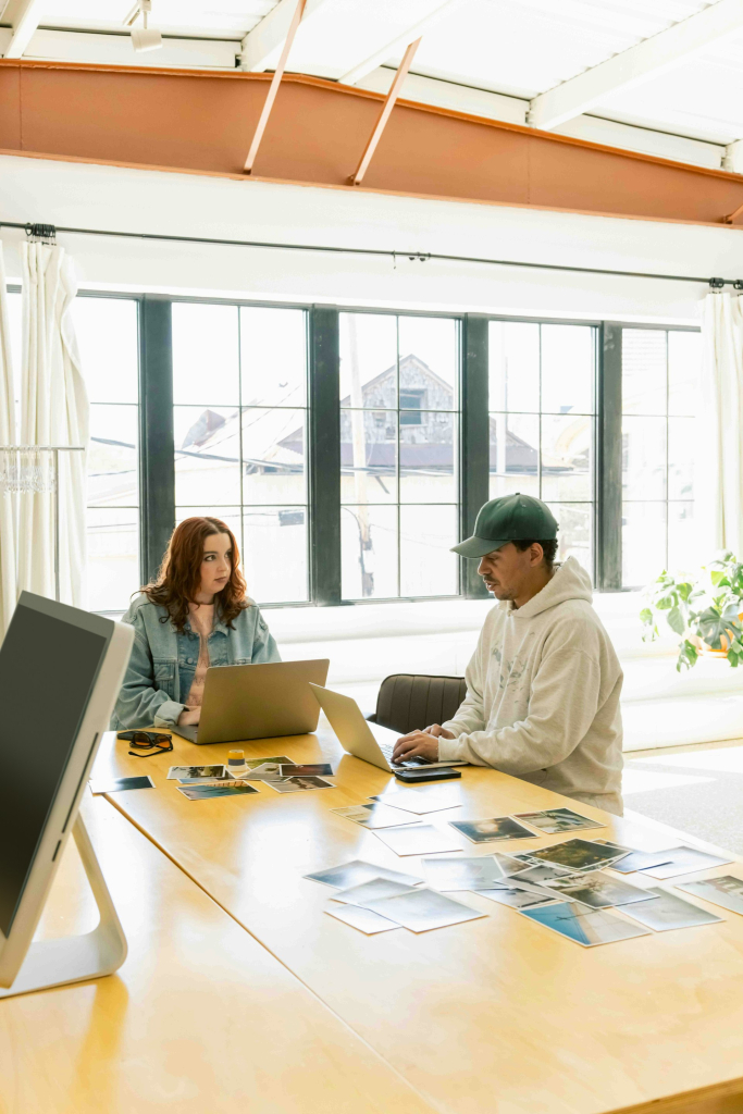 Deux personnes avec des ordinateurs portable autour d'une table